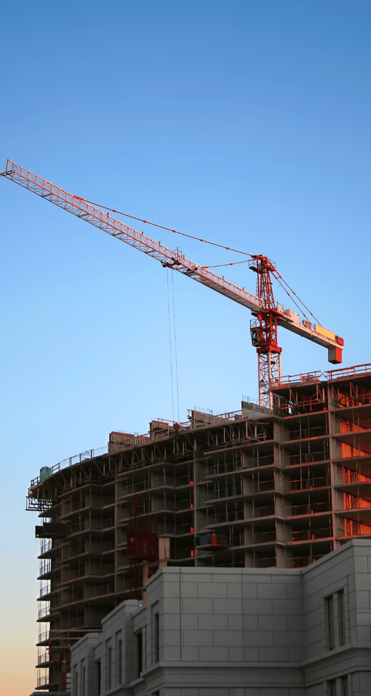 a large building under construction with a crane in the sky